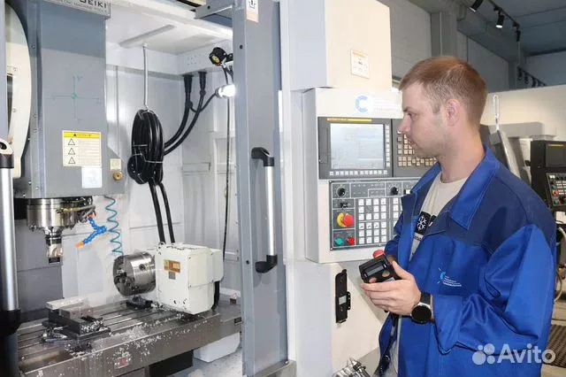 Оператор проверяет станок с ЧПУ на производстве
